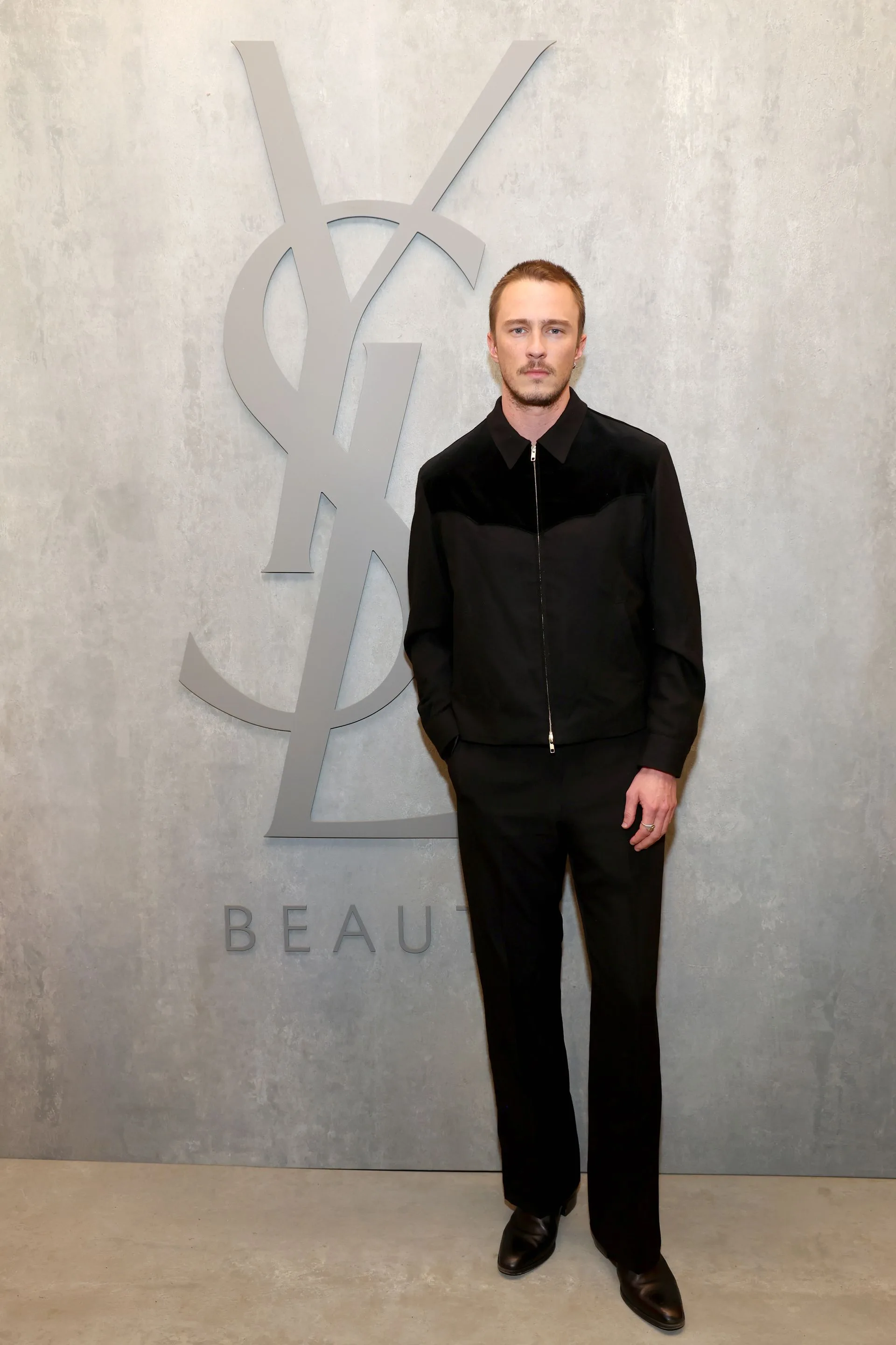 Image may contain Clothing Formal Wear Suit Coat Jacket Face Head Person Photography Portrait Standing and Adult